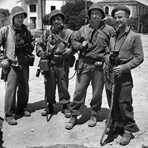 Allied soldiers of four different nations searching through the town of Littoria in Italy