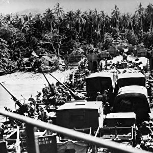 Allied soldiers and equipment despite Japanese flre, pour from on American LST
