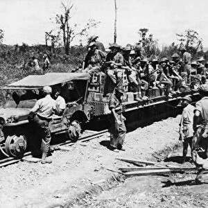 Allied troops use a jeep as a locomotive on the 37 mile railroad which runs from Mougang