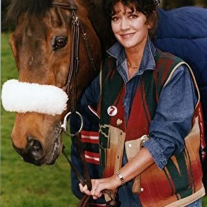 Amanda Barrie Actress standing next to Red Rum horse in a field