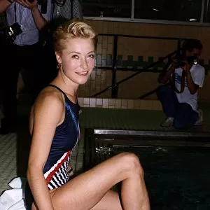 Amanda Donohoe British Actress sitting by a swimming pool with her feet in the water