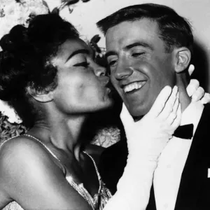 American actress and singer Eartha Kitt gives a kiss on the cheek to Roy Castle