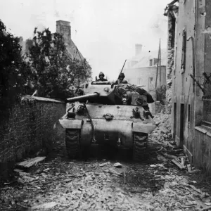 An American M-10 tank destroyer of the US Army rambles along a debris strewn road near An American M-10 tank destroyer of the US Army rambles along a debris strewn road near