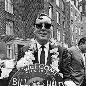 American rock and roll singer Bill Haley holds a record with a Welcome Back to Britain