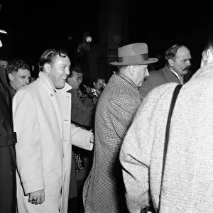 American rock and roll singer Bill Haley waves as he arrives in London for his UK tour