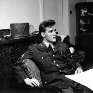 Le chanteur et musicien américain de rock and roll Elvis Presley photographié portant l'uniforme militaire. Le chanteur et musicien américain de rock and roll Elvis Presley photographié portant l'uniforme militaire.