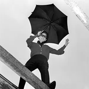 American singer Roy Orbison holding an umbrella at ATV House in London where he has