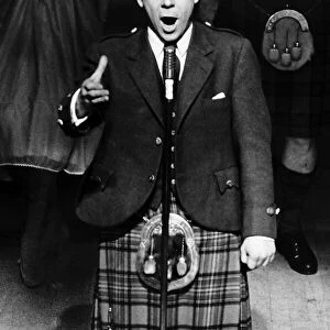 Andy Stewart Scottish singer tanding at microphone on stage mouth open arm out