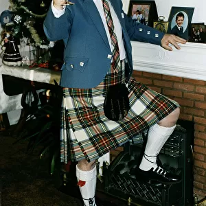 Andy Stewart singer holding goblet at home fireplace foot on fire christmass tree tartan