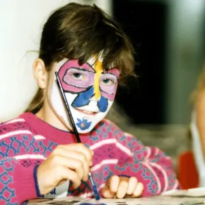 Angela Collins con su cara pintada como una mariposa disfruta haciendo algunos cuadros.