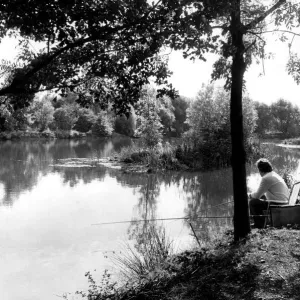 Angling. A fisherman sits patiently waiting for a bite at Kingsbury Water Park Angling. A fisherman sits patiently waiting for a bite at Kingsbury Water Park