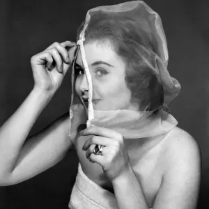 Ann Cave, model, poses with a make up mask, 29th October 1957
