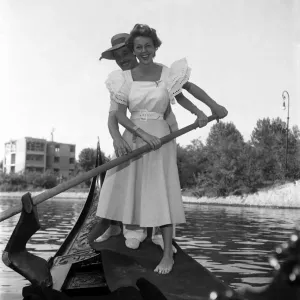 Ann French, actress posing with a gondolier in Venice, Italy. September 1952 C4555