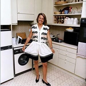 Anna Walker TV Presenter standing in kitchen holding out the legs of her shorts