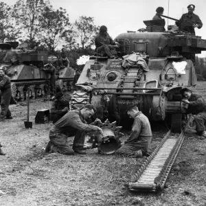 An armoured regiment overhauling one of their tanks Sherman for further battle against An armoured regiment overhauling one of their tanks Sherman for further battle against