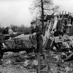 ARP rescue workers removing settee from blitzed army huts used as dwellings in a field in ARP rescue workers removing settee from blitzed army huts used as dwellings in a field in