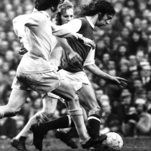 Arsenal footballer Charlie George fights off 2 Bradford defenders as he makes an attack