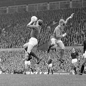 Arsenal goalkeeper Bob Wilson leaps up to claim a high ball from in front of Manchester
