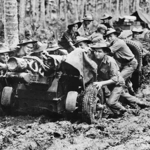 Australian-made 25 pounder being manhandled through the mud at Langemak Bay New Guinea