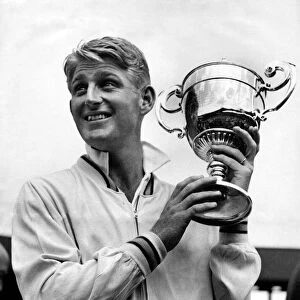 Australian tennis player Lew Hoad holding the championship cup after his finals match