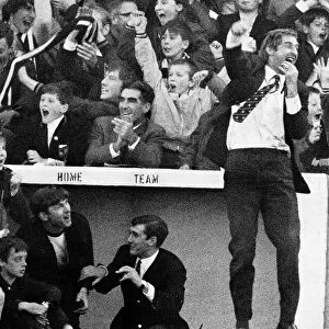 Ayr United manager Ally MacLeod jumps into the air outside the dug-out wearing a blazer