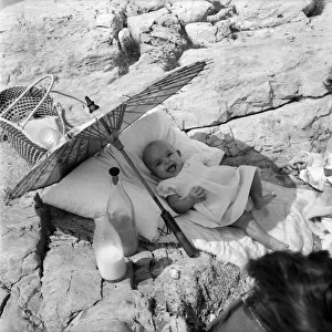 Baby under Sunshade beach pix. The happy baby is 4 months old Beverley Lovelock