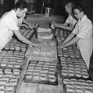 Bakers topping pies about to be put into the oven at a Edinburgh Bakery