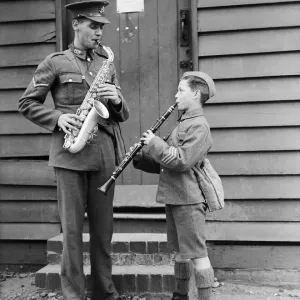 A South Staffordshire Regiment bandsman rehearses with a boy soldier in this print A South Staffordshire Regiment bandsman rehearses with a boy soldier in this print