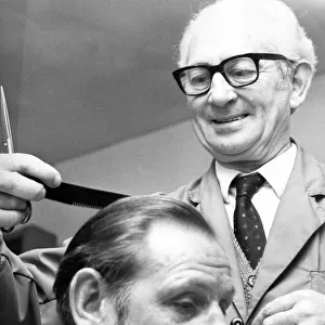 A barber cutting a mans hair in April 1972