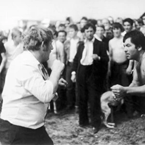 Bare - knuckle boxing on The Berkshire Downs. A large crowd surrounds two fighters for