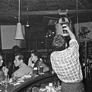 Barman at the Old Eden Saloon, Berlin loads a pint of beer into the sputnik for transport