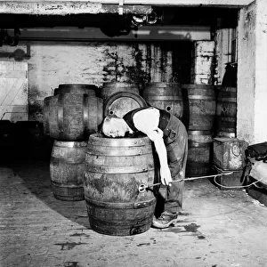 A barrel inspector at work at Hancocks Brewery in Cardiff. July 1952 C3603