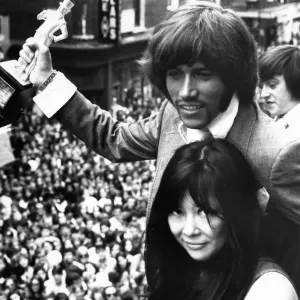 Barry Gibb of the Bee Gees holding the John Stephen statuette presented to him by Miss Barry Gibb of the Bee Gees holding the John Stephen statuette presented to him by Miss