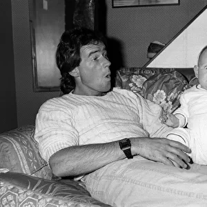 Barry Sheene with baby daughter Sidonie at home, May 1985