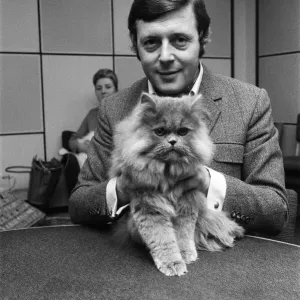 BBC commentator Michael Aspel at the BBC Studios at Lancaster Gate with a cat who is a