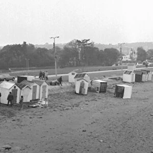 Beach huts strewn around Paignton beach in March 1973