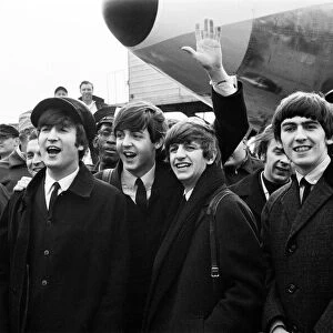 The Beatles arrive in New York for a 10-day tour on Pan Am Flight 101 at Kennedy Airport