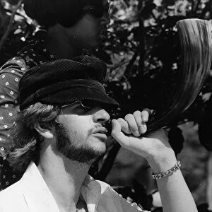 Beatles drummer Ringo Starr blowing a horn while on holiday in Tobago, January 1966