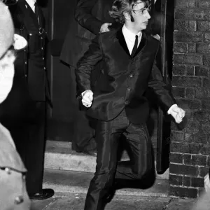 Beatles drummer Ringo Starr bolts from a side exit to a waiting car after the band Beatles drummer Ringo Starr bolts from a side exit to a waiting car after the band