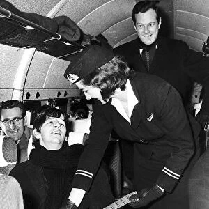 Beatles drummer Ringo Starr has his seat belt fastened air stewardess Sheila Whitworth
