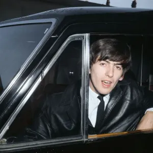 Beatles guitarist George Harrison leans out a car window during the band