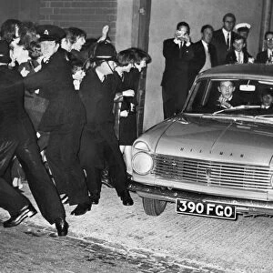 The Beatles in a Hillman with fans held back by the police at the Birmingham Hippodrome
