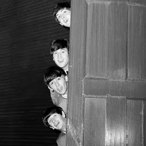 The Beatles peering out from behind a door. before the groups appearence at Sunday Night at the London Palladium, 13 October 1963. Top to bottom are: Paul McCartney, George Harrison, John Lennon, and Ringo Starr