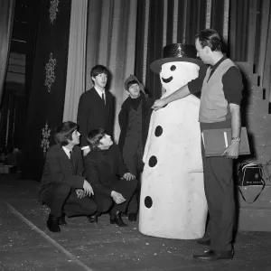 The Beatles pose with a Snowman, as they take a break from rehearsals at the Astoria
