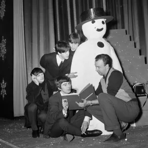 The Beatles pose with a Snowman, as they take a break from rehearsals at the Astoria