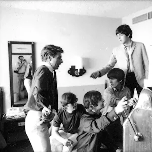 Beatles press officer, Derek Taylor, digs into his pocket for coins as the Beatles play