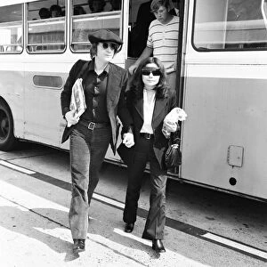 Former Beatles singer and songwriter John Lennon and wife Yoko Ono holding hands as they
