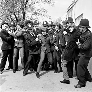 The Beatles in the strong arm of the law while filming "Help