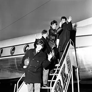 The Beatles wave from the steps of their plane at Yeadon airport after doing a show at