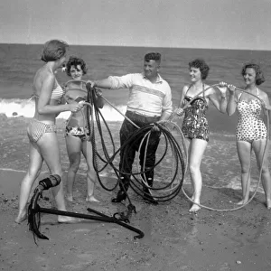 Beauty contest girls playing at Gt. Yarmouth, UK. seen here with a local fisherman